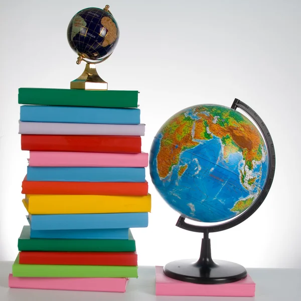 Stapel boeken en twee globe — Stockfoto