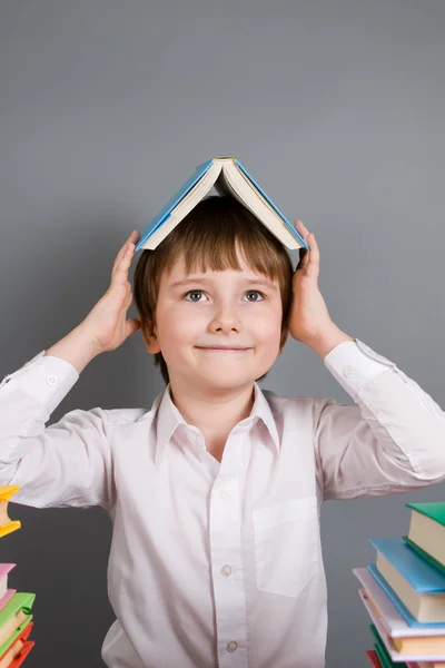 Jongen met een boek over het hoofd — Stockfoto