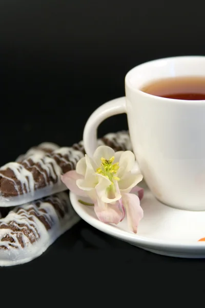 Белая чашка с чаем, печеньем и цветами — стоковое фото
