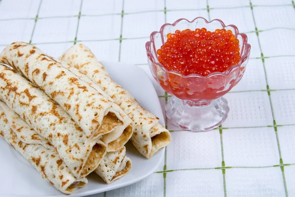 Tortitas con caviar rojo en un plato — Foto de Stock