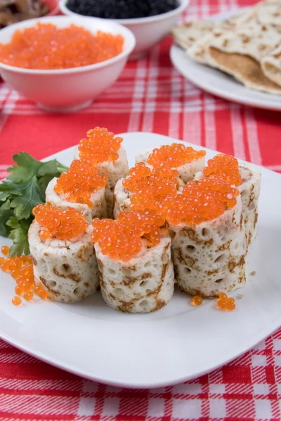 Rolls from pancakes with red caviar on a plate — Stock Photo, Image