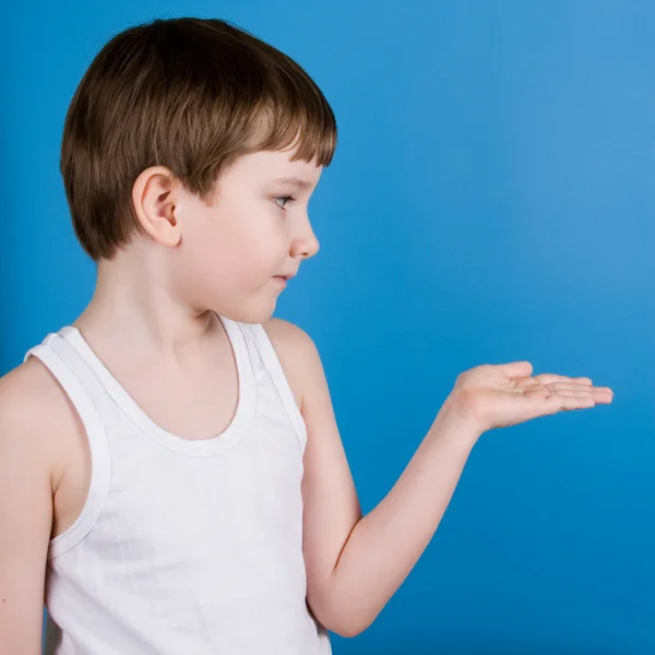 Мальчик смотрит на свою открытую руку — стоковое фото