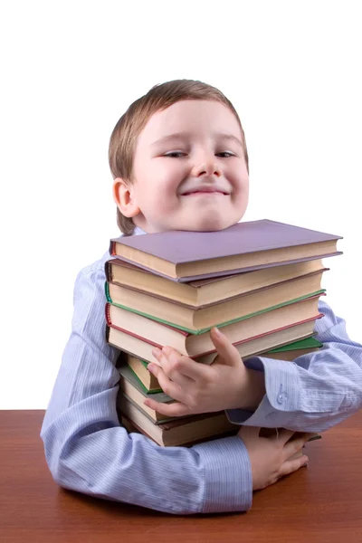 Joyeux garçon étreignant une pile de livres — Photo