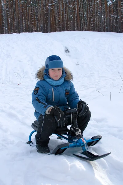 Веселий хлопчик гуляє в зимовому парку — стокове фото