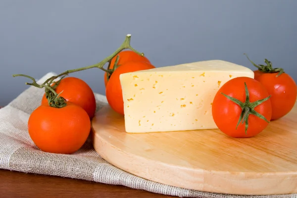 Yellow cheese with tomatoes — Stock Photo, Image