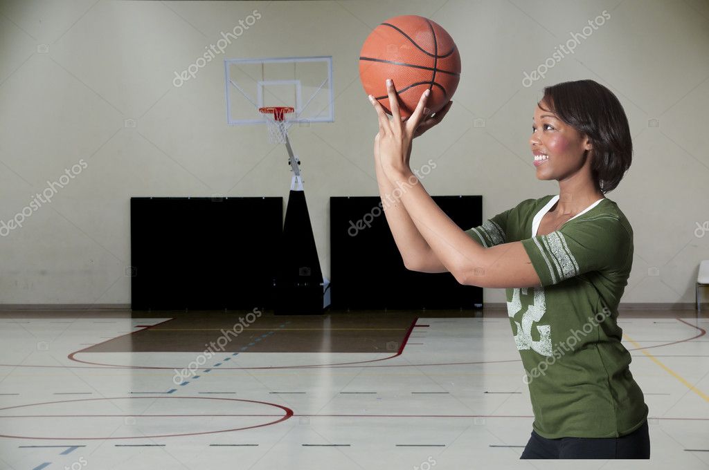 Joven Mujer afroamericana en vestimenta deportiva rebotando una pelota de  baloncesto en la cancha de deportes Fotografía de stock - Alamy