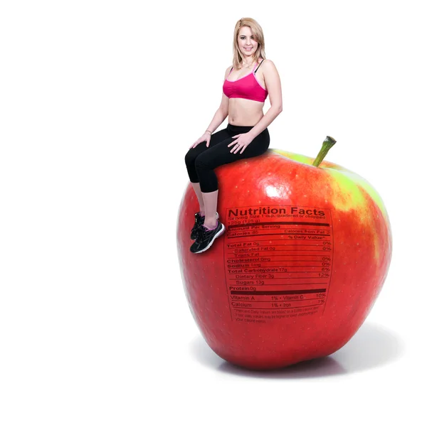 Frau sitzt auf rotem leckerem Apfel mit Nährwertaufkleber — Stockfoto