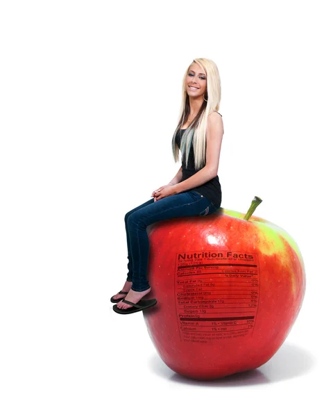 Mujer sentada en la manzana roja deliciosa con etiqueta nutricional — Foto de Stock