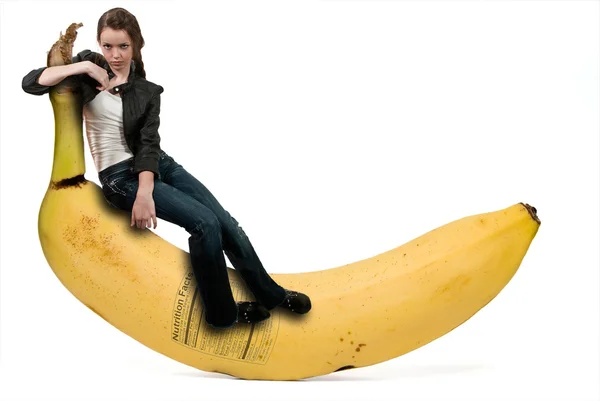Femme assise sur une banane avec étiquette nutritionnelle — Photo