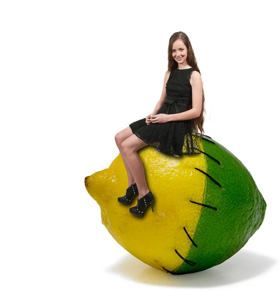 Mujer adolescente sentada sobre una lima de limón con etiqueta nutricional — Foto de Stock