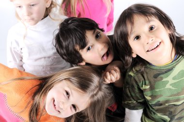 Group of happy playful children in studio clipart