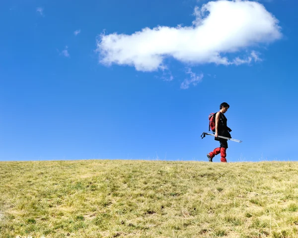 Woman mountaneering on grassland with cloud as copy space — Stock Photo, Image