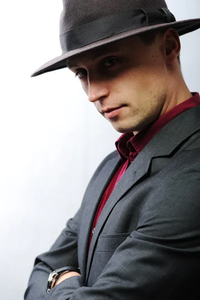 Elegante jonge man met een hoed camera kijken — Stockfoto