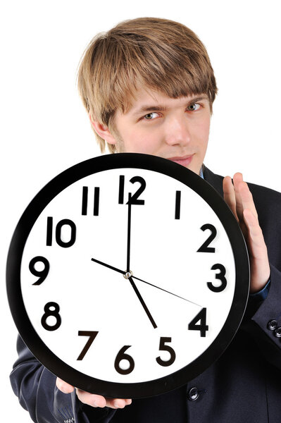 Handsome teenage guy holding clock in his hands