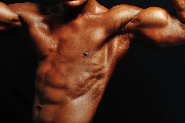 Muscular male torso of bodybuilder on black background — Stock Photo, Image