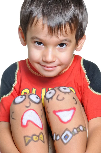 Süßer kleiner Junge mit aufgemalten Smileys auf seinen Beinen — Stockfoto