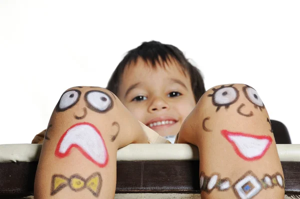 Niño pequeño con emoticonos pintados en las piernas —  Fotos de Stock