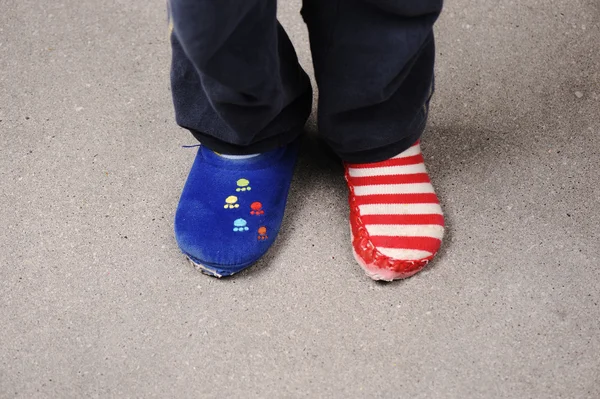 Twee verschillende sokken op de voeten van de kleine jongen — Stockfoto