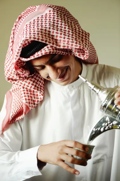 Hombre joven árabe vertiendo un café tradicional — Foto de Stock