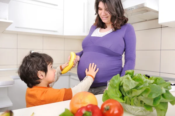 怀孕的女人与她的儿子在厨房里 — 图库照片