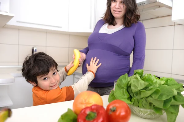 Pregnant woman with her boy in kitchen — Stock Photo, Image