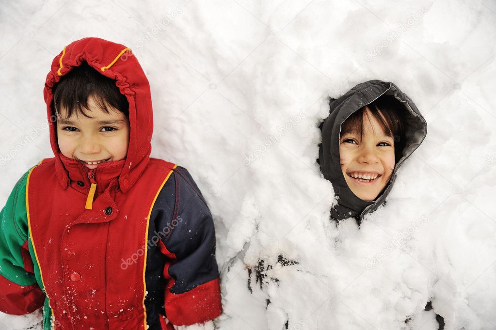 Two boys laying in snow