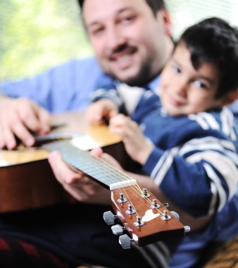 Baba ve oğul evde gitar çalmak
