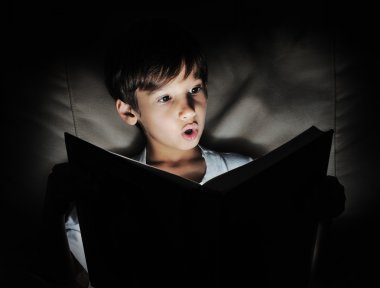 Kid reading book, light in darkness clipart