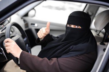 Arabic Muslim woman driving a car and happy for that clipart