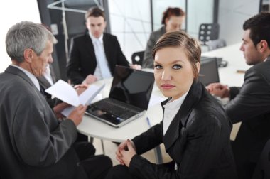 Portrait of successful businesswoman and business team at office meeting