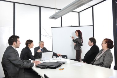 Businesswoman drawing a diagram during the presentation clipart