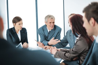 Portrait of a positive manager with his team sitting at the table clipart