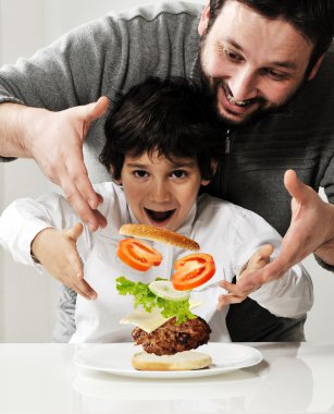 Kid and father making burger together clipart