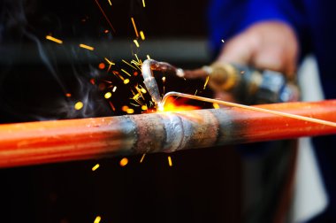 Welder using torch on metal object clipart