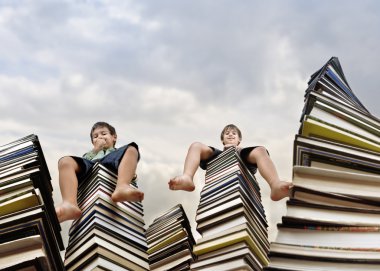 Little boy sitting on large stack of books clipart