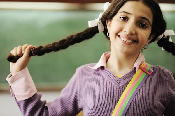 Χαριτωμένο κοριτσάκι με πλεξούδες τα μαλλιά στο σχολείο — Φωτογραφία Αρχείου