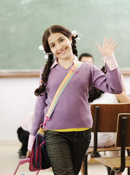 Roztomilá holčička ve škole rčení hello — Stock fotografie