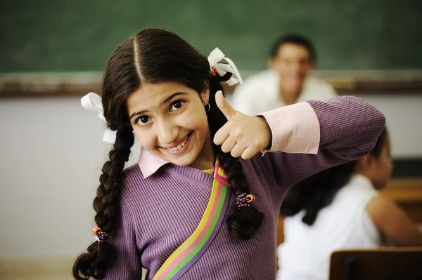 Aranyos kis lány az iskolában, a hüvelykujjával felfelé — Stock Fotó