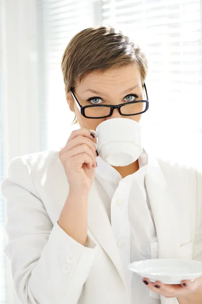 Junge Geschäftsfrau trinkt Kaffee im Büro — Stockfoto