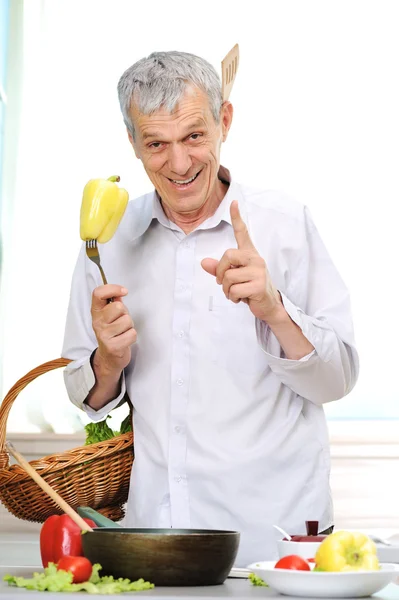 Homem idoso bonito que trabalha na cozinha — Fotografia de Stock