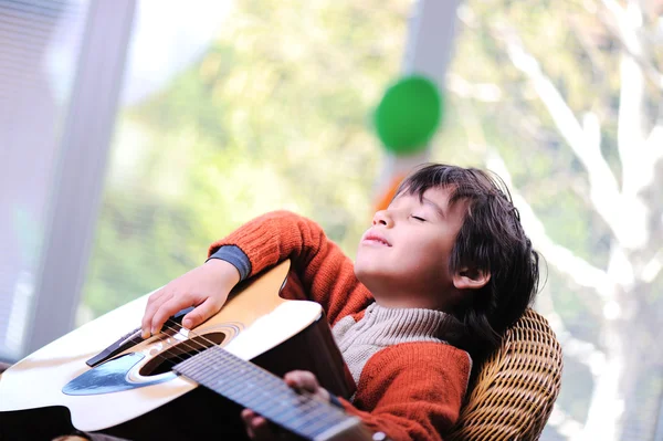 Enfant jouant de la guitare à la maison — Photo