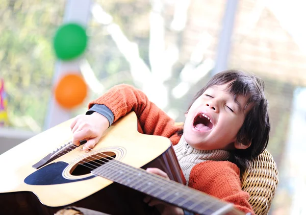 Παιδί, τραγουδώντας και παίζοντας κιθάρα στο σπίτι — Φωτογραφία Αρχείου