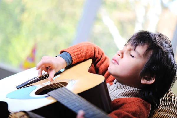 Petit garçon jouant de la guitare à la maison — Photo