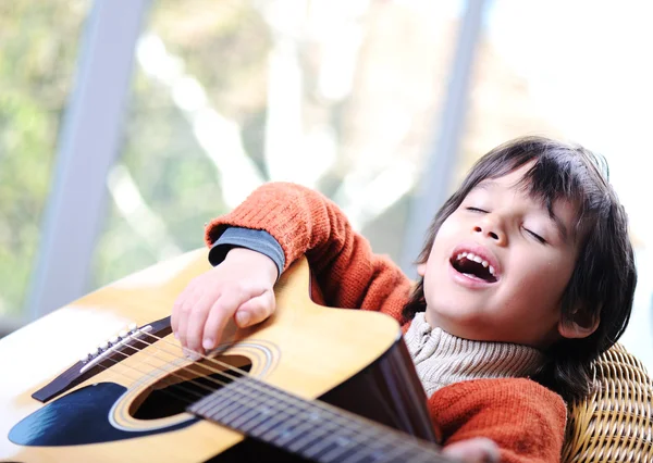 Маленький хлопчик грає на гітарі вдома — стокове фото