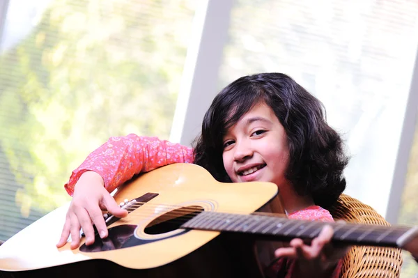 弹吉他在家里的小女孩 — 图库照片