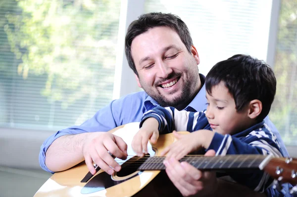 Pai e filho tocando guitarra em casa — Fotografia de Stock