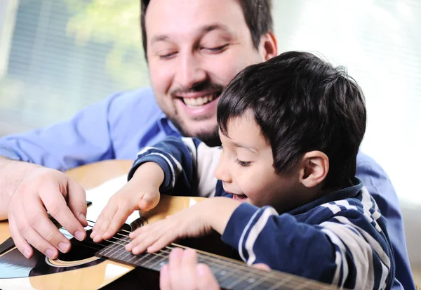 Far och son spelar gitarr hemma — Stockfoto