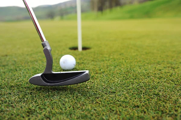 Golfbal en stok op groen gras — Stockfoto