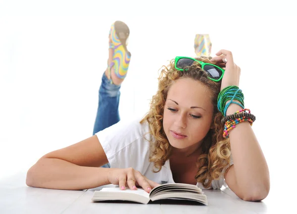 Female teenager laying and reading book — Stockfoto