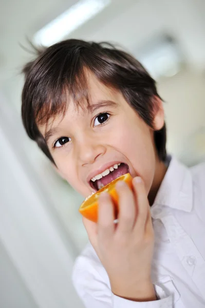 Taze turuncu meyve yiyen çocuk — Stok fotoğraf
